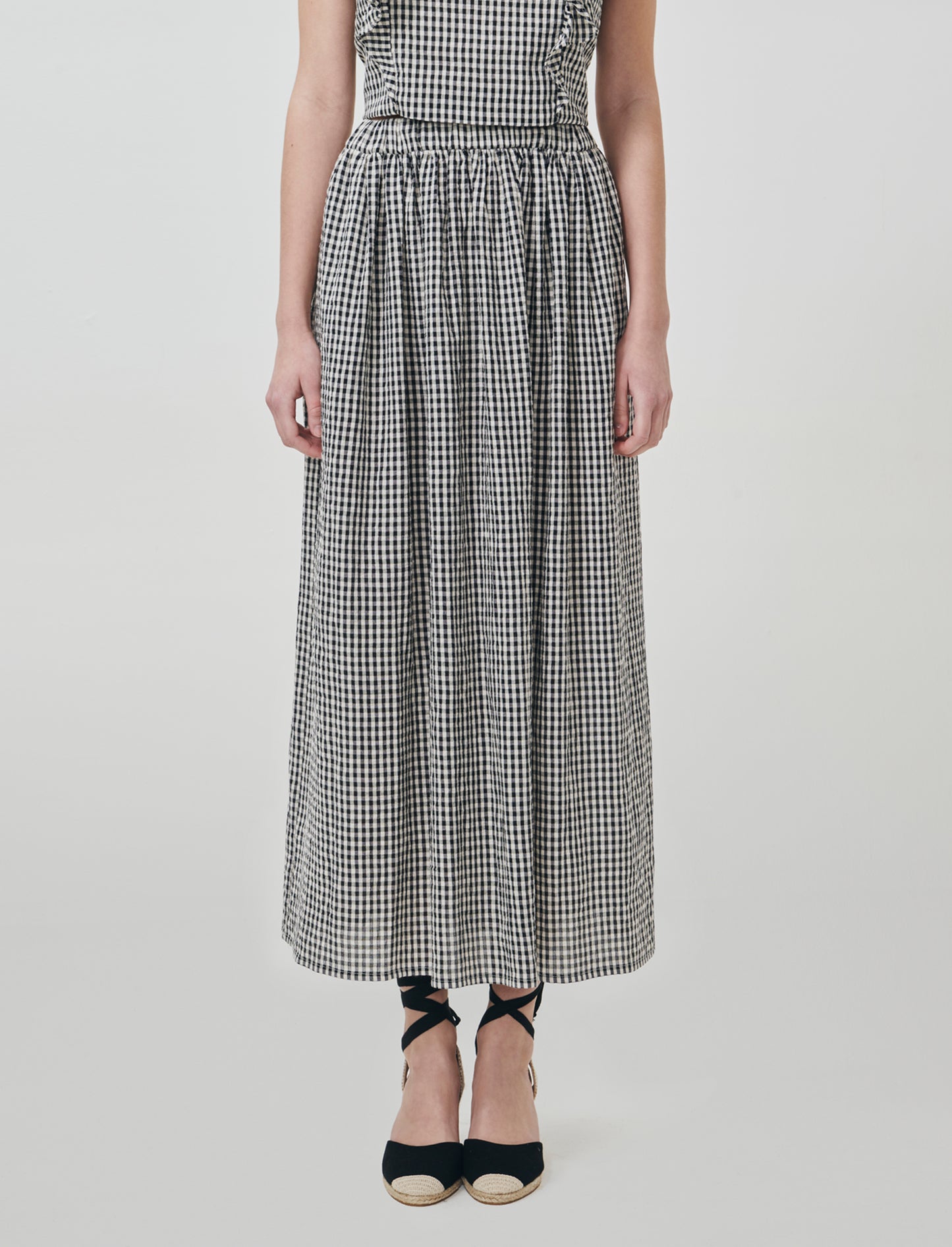 Introducing the Vichy-printed long skirt, a stylish and versatile addition to any woman's wardrobe. - Black