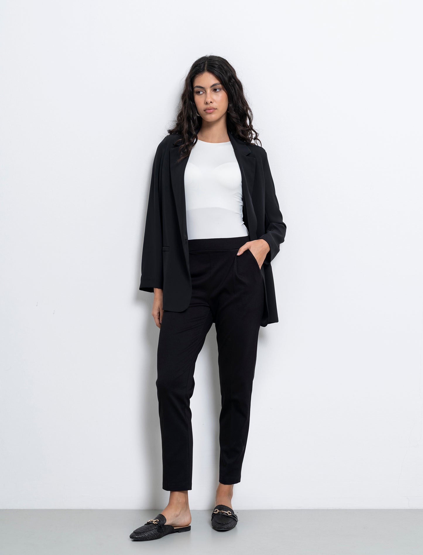 Pantalone elegante con taglio dritto, pieghe frontali e fascia elastica in vita. - Nero