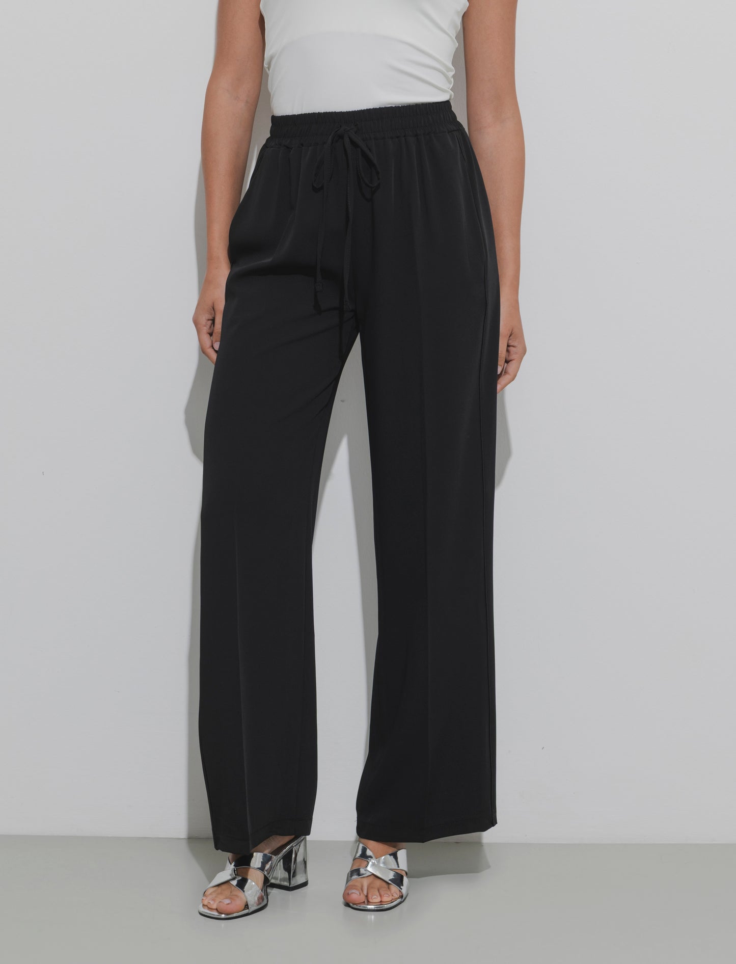 Pantalone palazzo con vita elasticizzata e coulisse regolabile. - Nero
